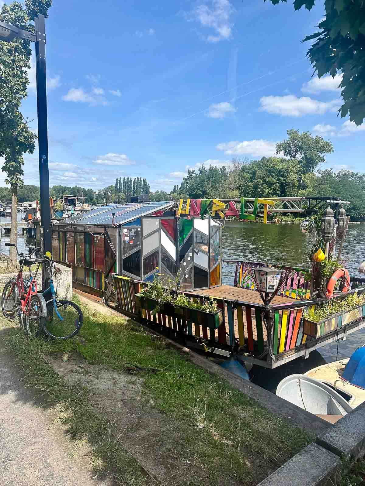 Colorful Houseboats on the River: Houseboats painted in bright colors moored along the riverbank.