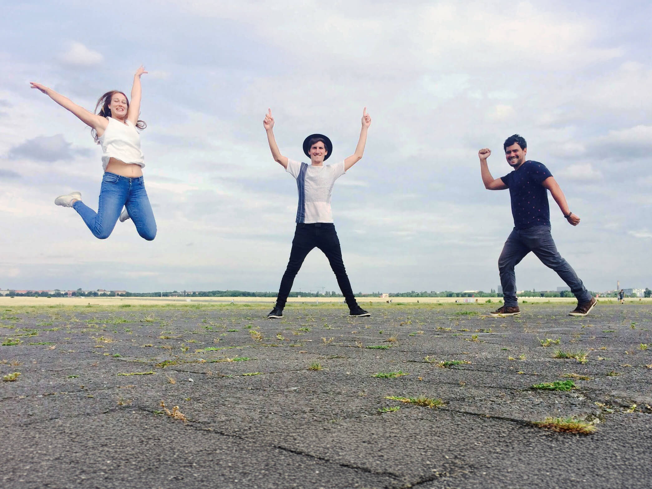 Friends Jumping in the Park: Three friends jumping in the air in an open area of a park.