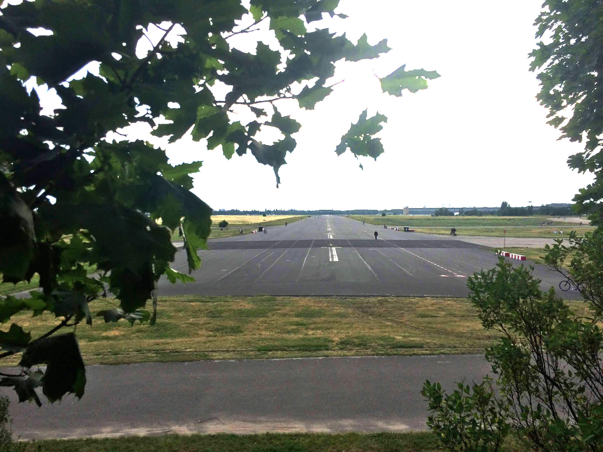 Abandoned Airstrip in Tempelhofer Feld: People walking and relaxing on the wide-open space of the former Tempelhof Airport.