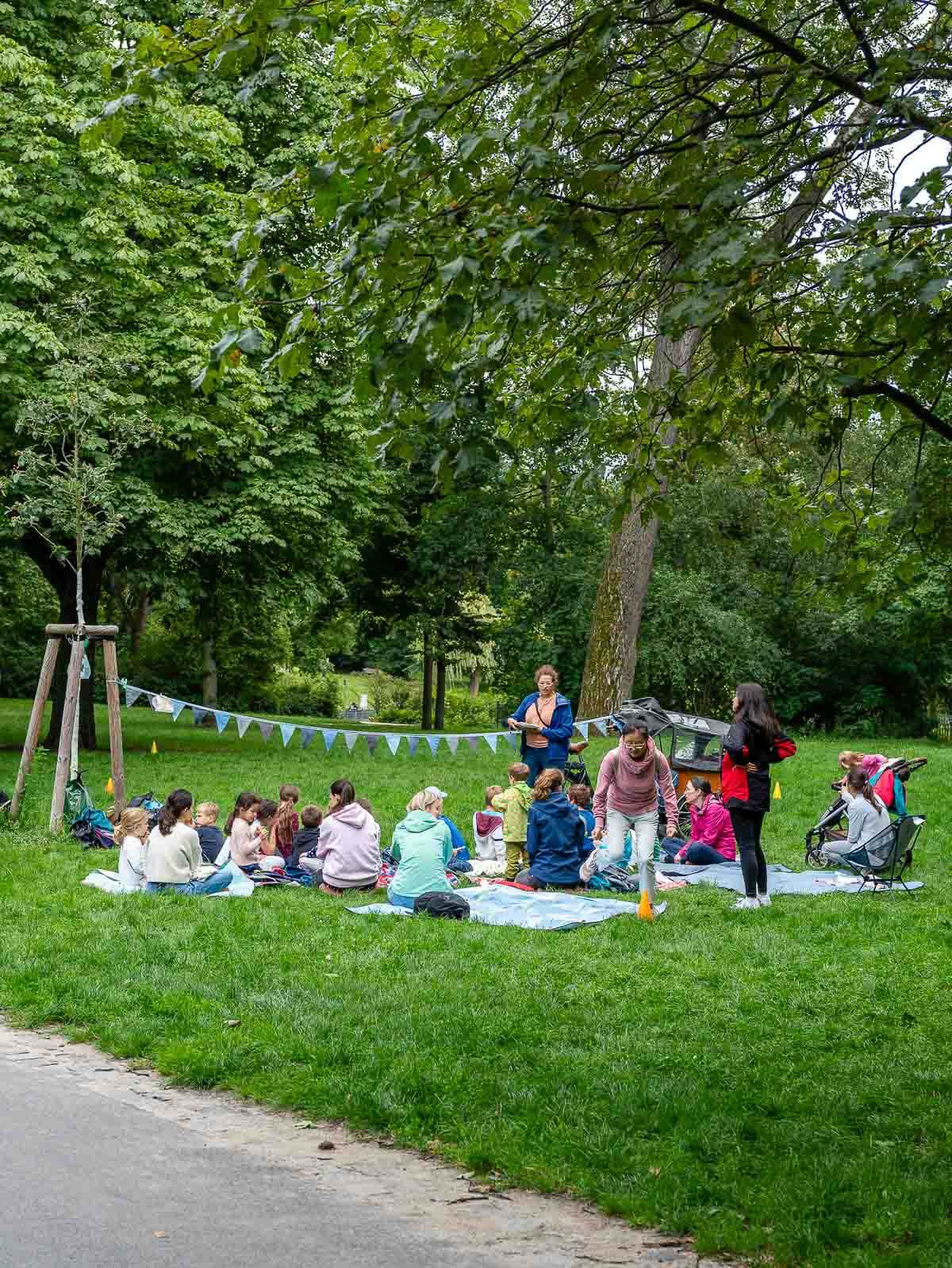 Picnic in the Park: A group of people having a picnic on the grass under the shade of trees.