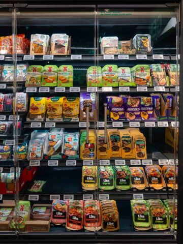 A grocery store aisle filled with a wide variety of vegan products, including plant-based meats and dairy alternatives.