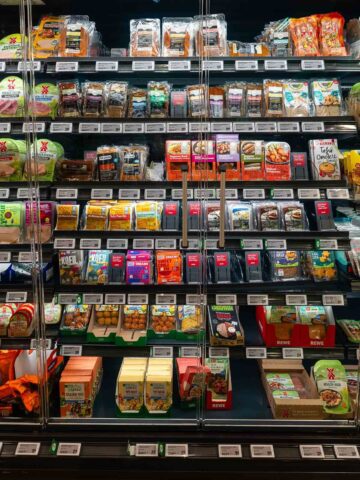 An aisle in a grocery store showcasing a wide range of vegan products, including snacks and plant-based pantry items.