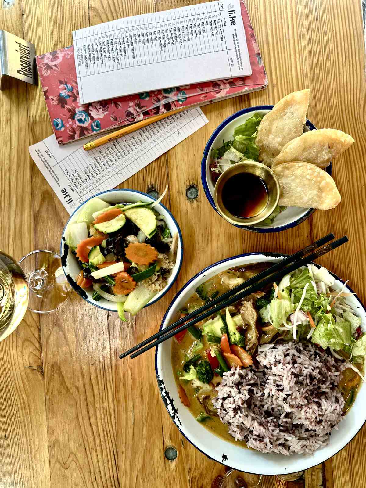 vegan duck curry with rice in a bowl next to a mushroom and tofu bowl and fried dumplings in a Thai restaurant in Berlin.