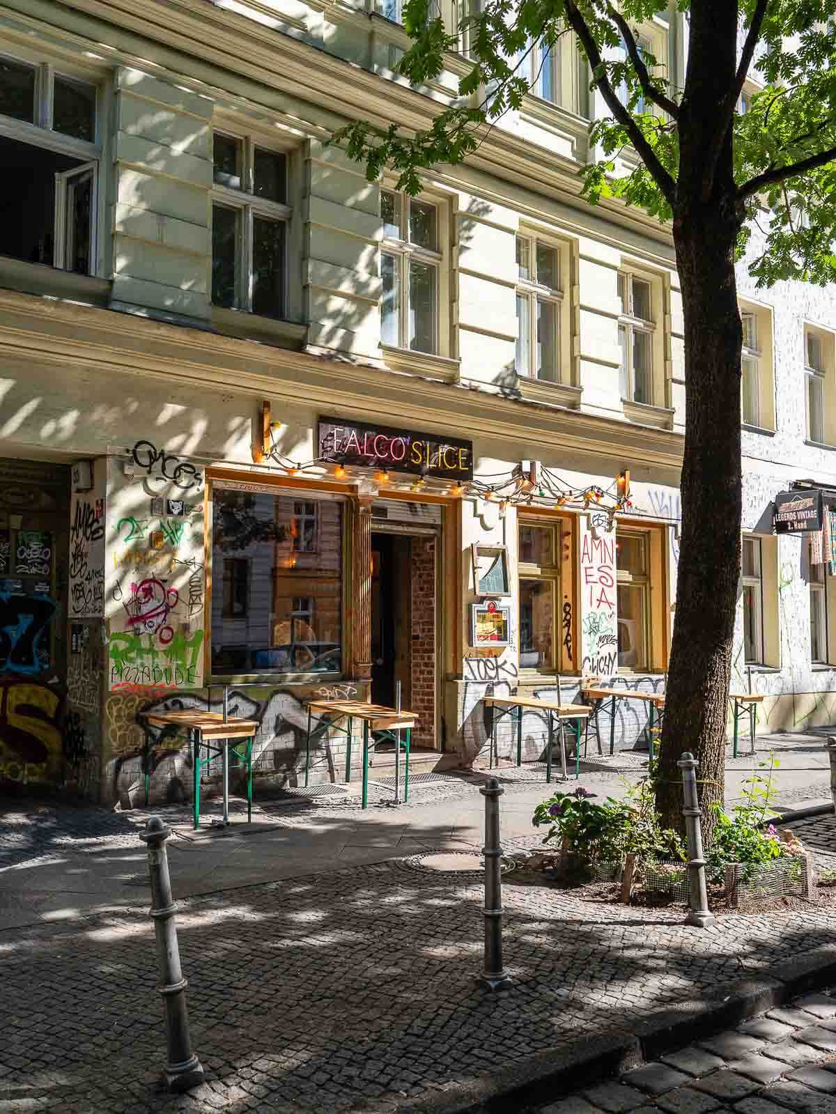 A cozy outdoor seating area of a vegan café in Berlin, with patrons enjoying their meals.