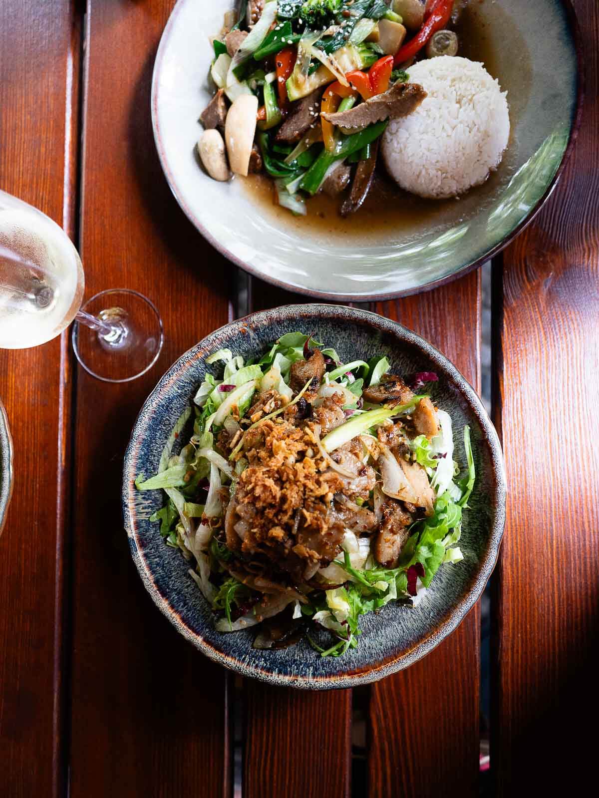 A bowl of fresh vegan salad topped with crispy plant-based protein, served at a Berlin eatery.