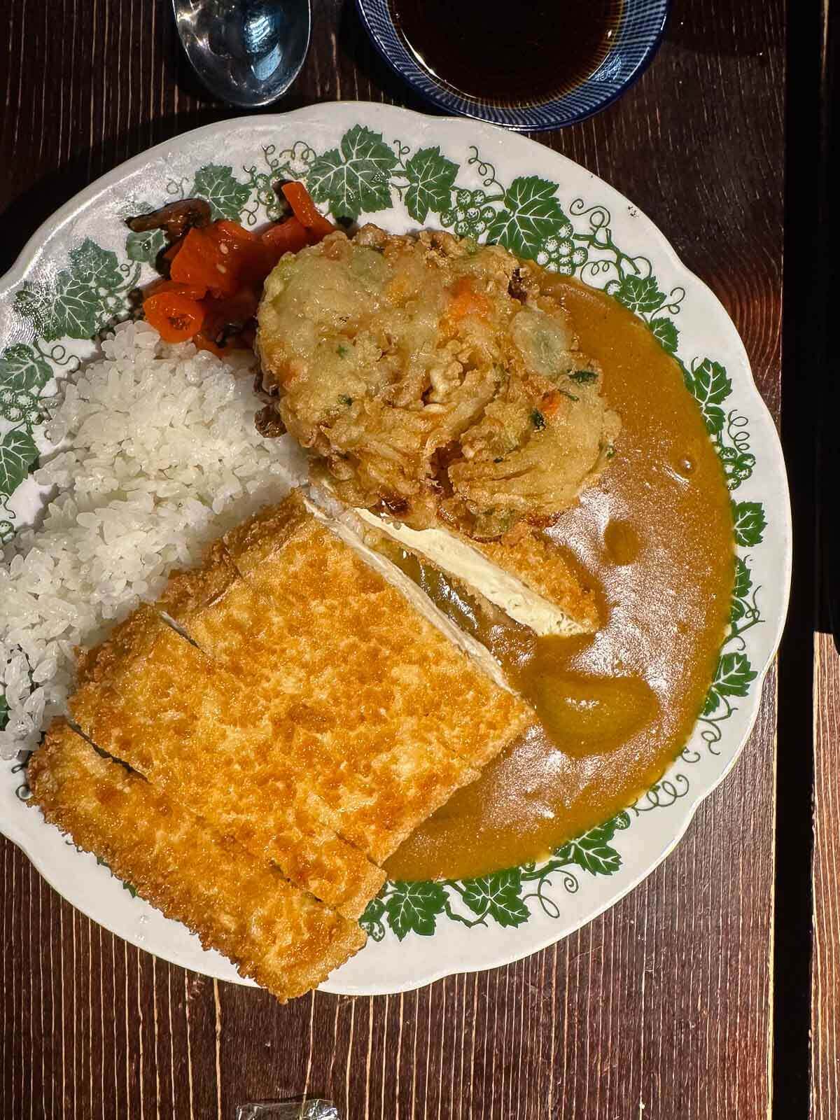 A plate of vegan plant-based katsu with rice, vegetables, and a creamy sauce at a Berlin restaurant, Iro Izakaya Vegan.