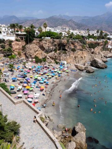 crowded beach with colorful umbrellas at Playa Calahonda.