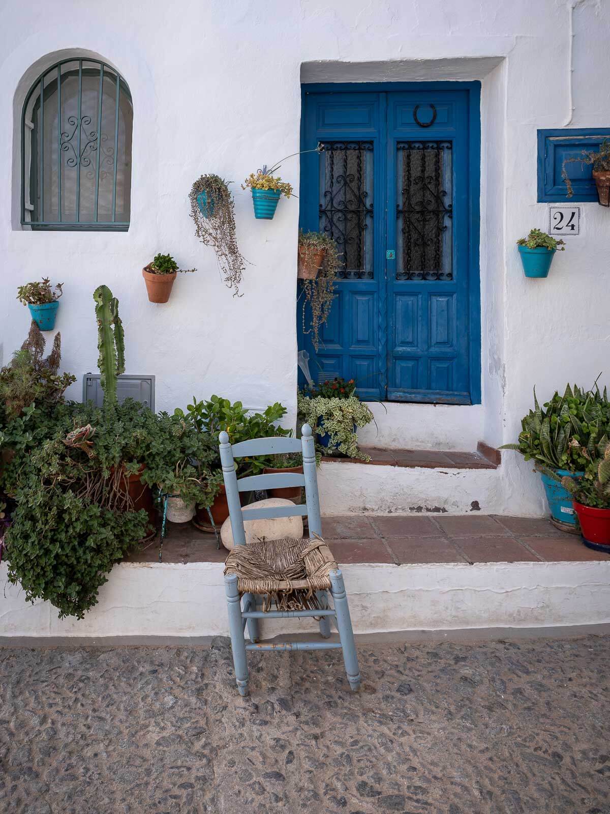 A charming doorway with blue accents and potted plants in the village of Frigiliana.