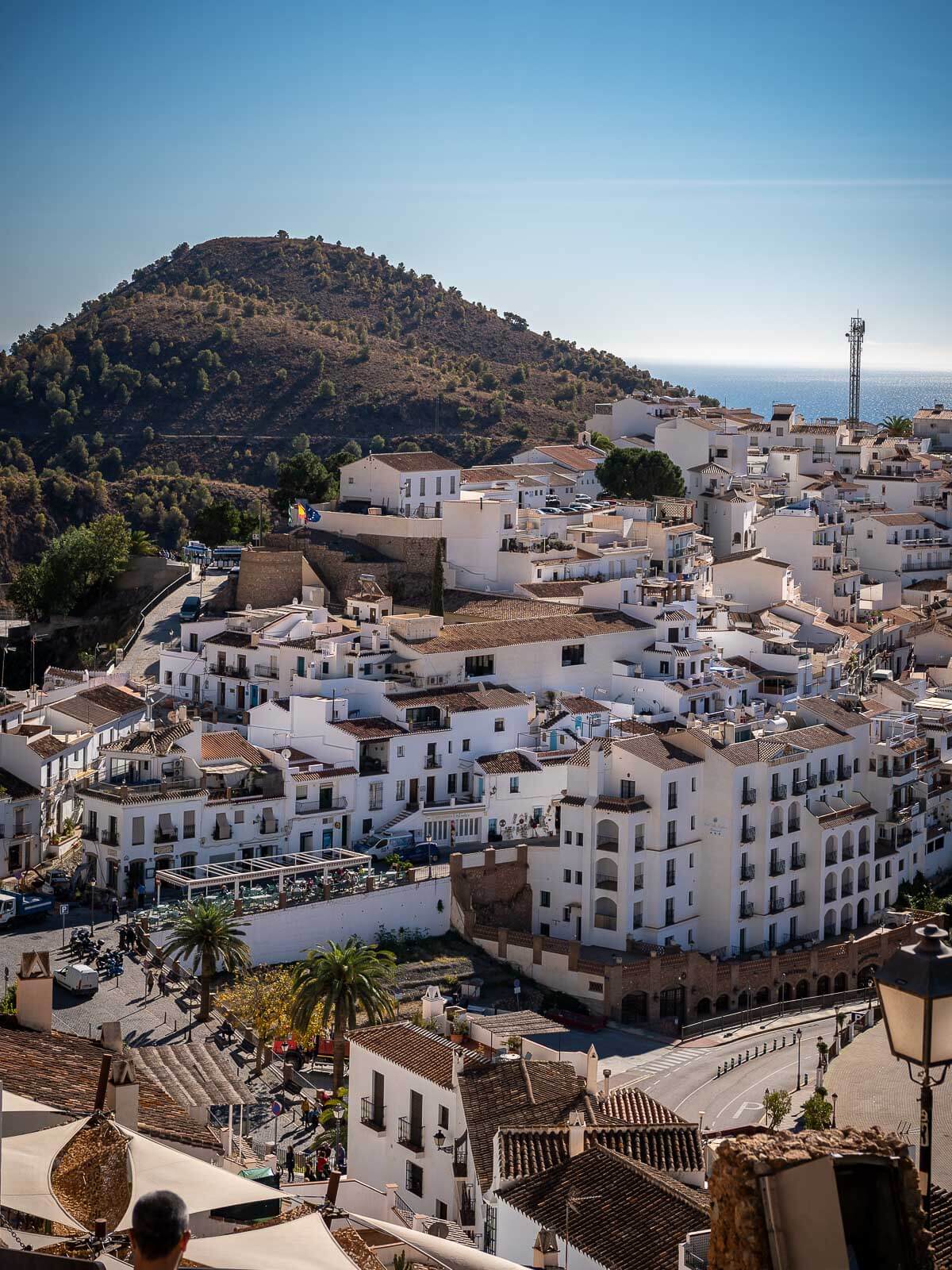 A panoramic view of Frigiliana showcasing its whitewashed buildings nestled in the hills.