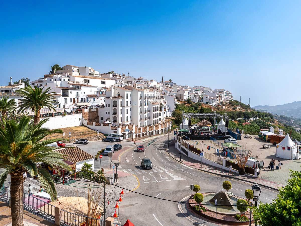 A panoramic view of Frigiliana's whitewashed houses and winding streets under a clear blue sky.