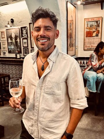 man with a glass of wine inside of Bar La Tranca.