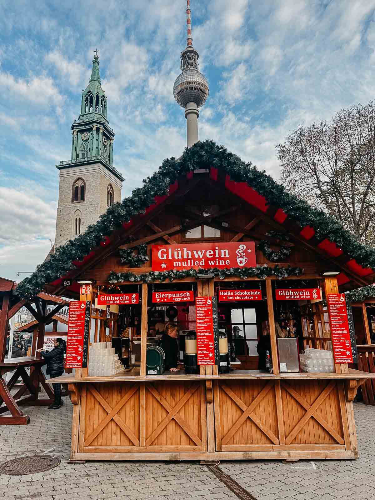 A picturesque wooden stall at a Berlin Christmas market, surrounded by festive decorations.