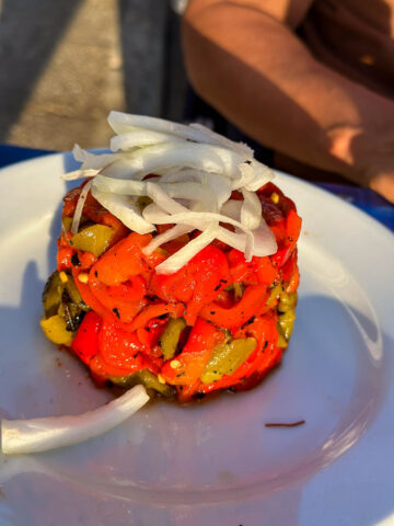 A colorful roasted vegetable stack with onions, showcasing Málaga’s fresh and flavorful plant-based dishes.
