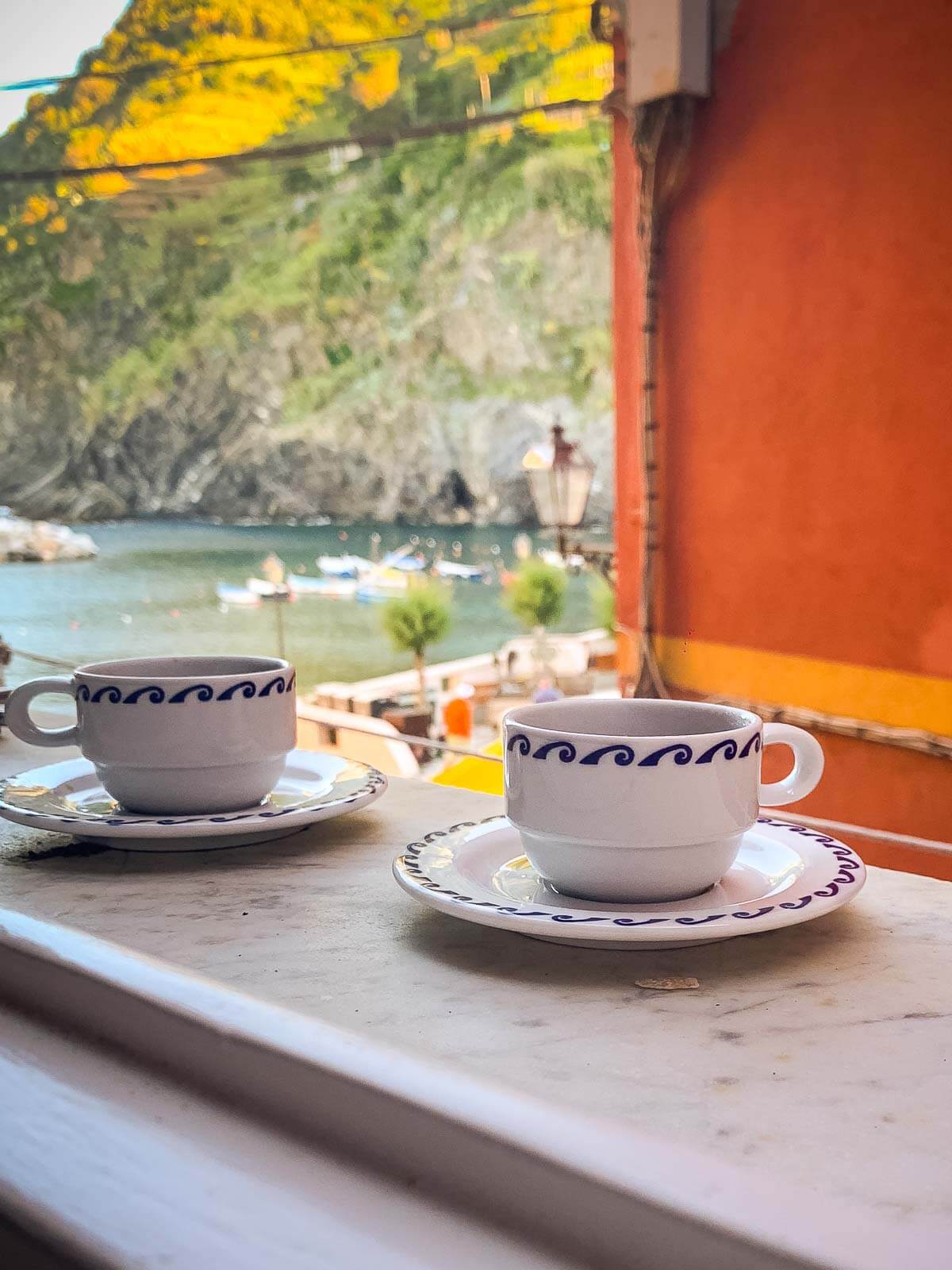 Two cups of coffee on our window with a view of the bay in Vernazza.