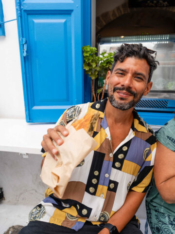 Enjoying a fresh spinach pie on the streets of Mykonos.