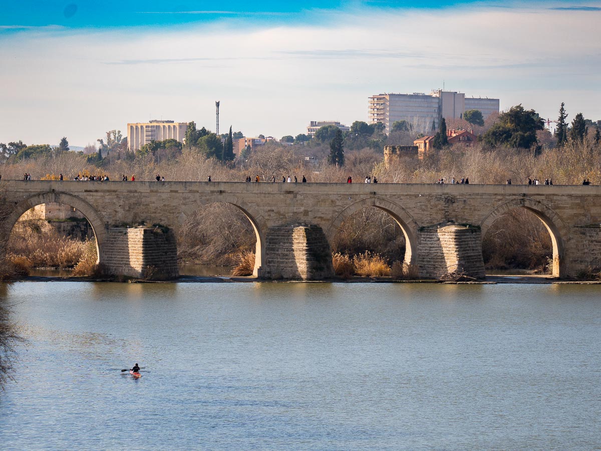 Roman Bridge of Córdoba crossing the Guadalquivir River at midday.